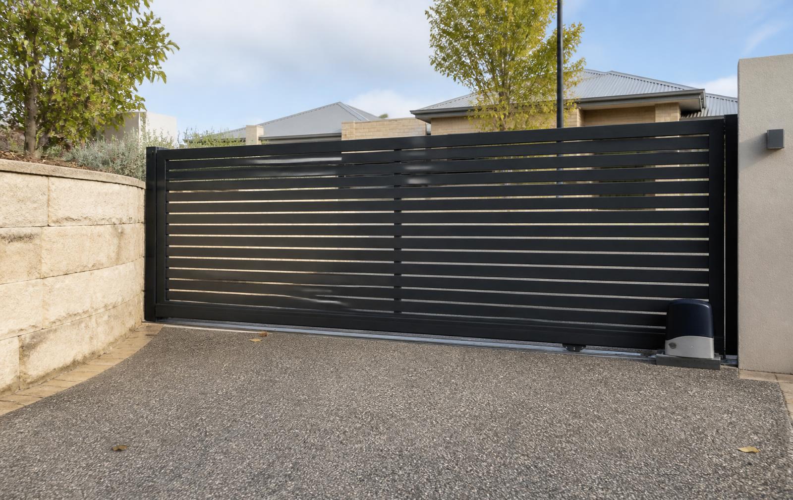 Dark charcoal powder coated horizontal slat sliding driveway gate at a home
